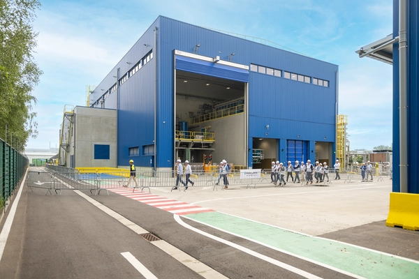 Foto: Aurubis: Eine blaue Halle von außen, das Tor ist auf