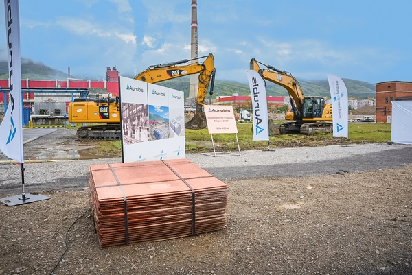 Foto: Aurubis: Mehrere gebuendelte Platten, zwei gelbe Bagger im Hintergrund
